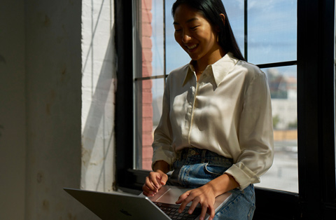 Apple Store employee standing next to a customer, both interacting with a MacBook.
