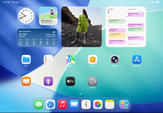 iPad, three models, landscape orientation, with centre model in front of two others, Apple Pencil magnetically attached to top of centre model, centre screen showing the Home Screen featuring colourful app icons with Liquid Glass effect, left screen showing the app, right screen showing Home Screen with files fanning out from the Dock