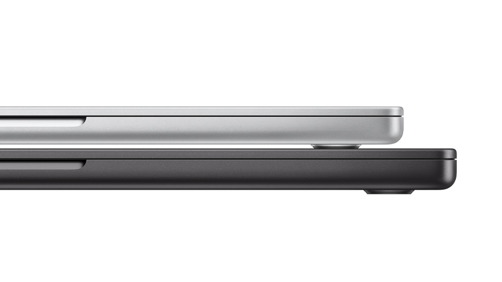 Widok z boku na dwa zamknięte laptopy Mac, jeden na drugim.