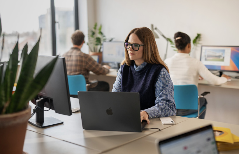 De marketingmedewerkers van Hello Vet werken op een MacBook Pro om samen marketingcontent te maken.